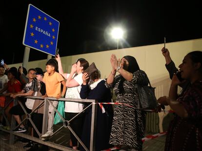 Varias personas apostadas junto a la frontera del Tarajal, en el lado español del límite entre España y Marruecos, la noche de este lunes.