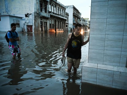 Dos personas atraviesan una de las calles inundadas por el paso del huracán 'Ian', en La Habana (Cuba), el 28 de septiembre de 2022.