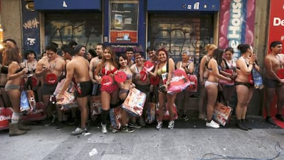 Varias personas esperan a las puertas de un comercio en Madrid, donde arrancan las rebajas con la campa&ntilde;a &#039;Entra desnudo y sal vestido&#039;. 