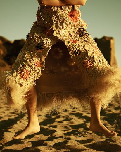 Chaleco de rafia bordado
con apliques florales
de plumas y croché de Delpozo (c. p. v.).