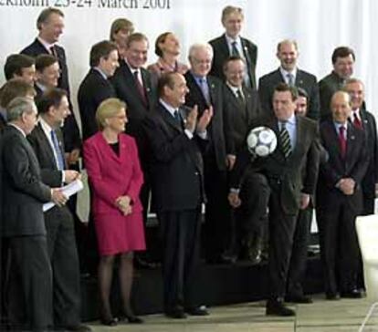 El presidente francés, Jacques Chirac, aplaude al canciller alemán, Gerhard Schröeder, que juega con un balón.