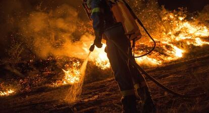 Un brigadista trabaja esta noche en las labores de extinción de un incendio