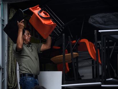 Un trabajador acomoda e las pertenencias de un inmueble en una camioneta de fletes y mudanzas.