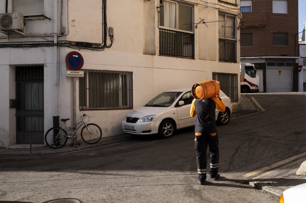 Un trabajador lleva una bombona de butano.