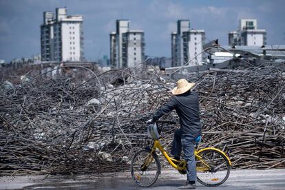 Un hombre sentado en una bicicleta observa los restos del mercado de los muebles de Jiuxing, en los suburbios de Shangái.