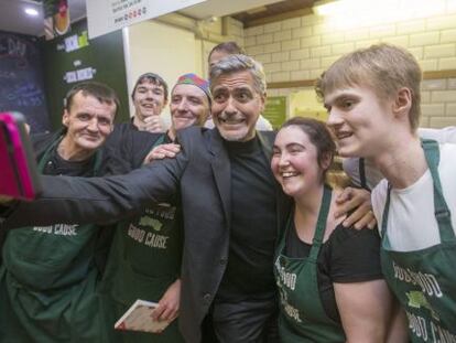 George Clooney posa con trabajadores de la cafetería Social Bite Cafe, en Edimburgo, Escocia.