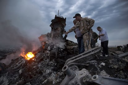 Um grupo de pessoas inspeciona os restos do avião que caiu na localidade de Grabovo, na região de Donetsk, em Ucrânia.