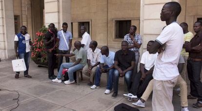 Un grupo de inmigrantes espera al ministro de Exteriores de Senegal a las puertas del Ayuntamiento de Alicante.
