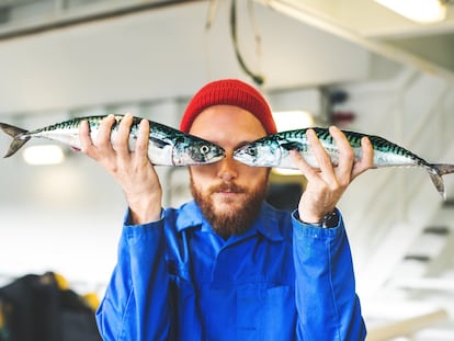 Fisherman with fresh fish on the fishing boat deck