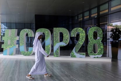 Un delegado pasa delante del símbolo de la COP28, durante un encuentro empresarial, el pasado 1 de octubre en Abu Dabi.