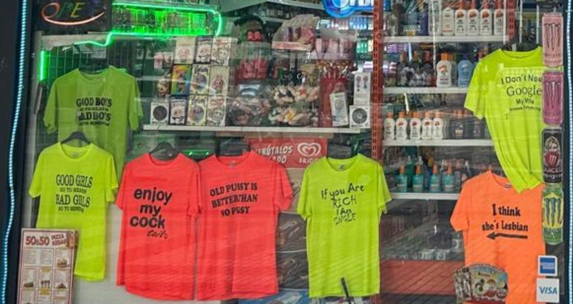 Escaparate de una tienda de Benidorm con camisetas con lemas sexistas y obscenos.