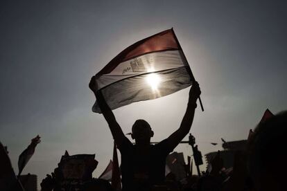 Un manifestante sujeta la bandera de Egipto durante la protesta multitudinaria contra el presidente egipcio Hohamed Morsi en la plaza Tahrir de El Cairo, 1 de julio de 2013.