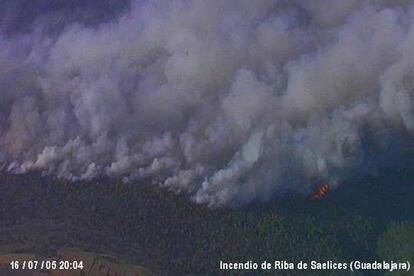 En esta espectacular imagen el denso humo parece tragarse las hectáreas de bosque guadalajareño. Las llamas se originaron eses sábado por una barbacoa encendida por unos excursionistas en el paraje de Los Jarales, en Riba de Saelices.