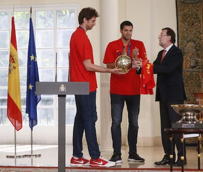 Pau Gasol, en presencia del capitán de la selección española de baloncesto, Felipe Reyes (c), entrega la copa de Europa de baloncesto al presidente del Gobierno, Mariano Rajoy, durante la visita del equipo al Palacio de La Moncloa.