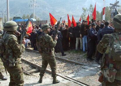 Soldados turcos vigilan a los manifestantes que ayer trataban de bloquear el puerto de Iskenderun.