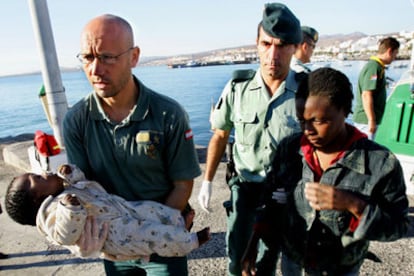Un agente lleva en brazos a un bebé de dos meses que viajaba en la patera interceptada en aguas de Fuerteventura.