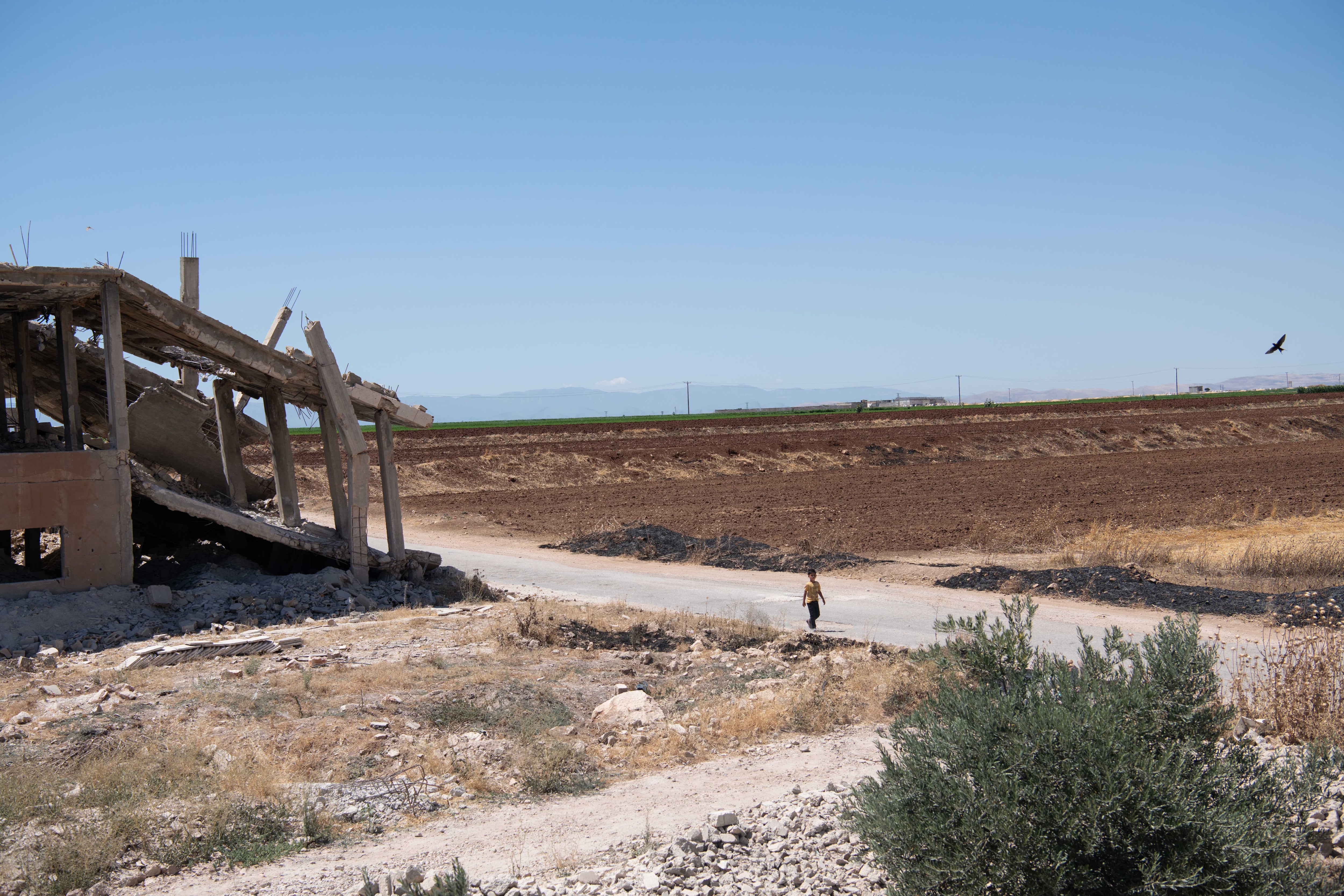 Un niño camina por el poblado Al Hamameyat de la periferia de Hama, donde su familia ha regresado tras años desplazados en un campo de refugiados en Turquía, el pasado 28 de julio.