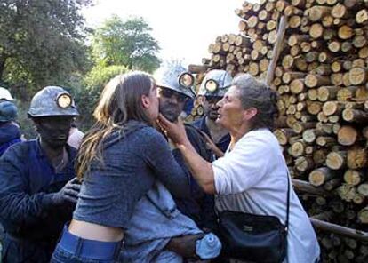 En la imagen, uno de los mineros rescatados recibe el abrazo de su esposa y su madre.