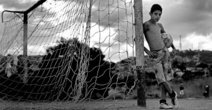 Un niño juega al fútbol en la favela de Belo Horizonte.