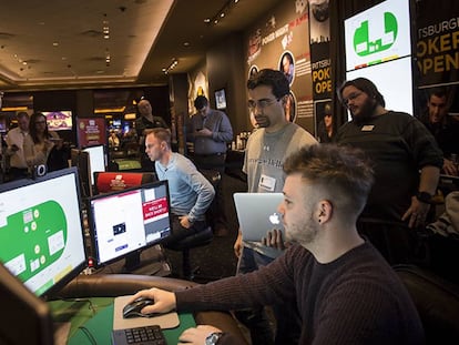 Sandholm, à esquerda, de gravata, e Brown, com um laptop na mão, durante uma experiência do Libratus contra campeões de pôquer.