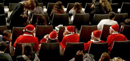 Un grupo de amigos disfrazados de Papá Noel esperan en el Palacio de Congresos de Madrid el comienzo del sorteo extraordinario de Navidad