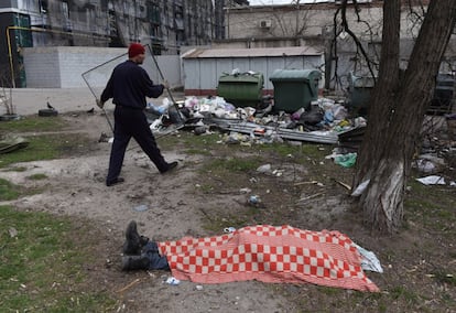 Un hombre pasa junto a un cadáver en la ciudad costera de Mariupol. El Gobierno de Ucrania ha logrado evacuar en las últimas 24 horas a 2.694 personas de las zonas más castigadas por el ejército ruso, especialmente de esta localidad del sudeste de Ucrania, sitiada desde hace más de un mes, y cuyos habitantes aguantan sin luz, agua y apenas suministros.