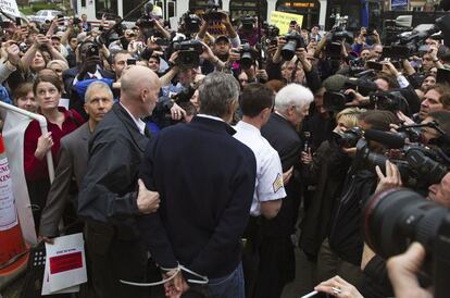 El actor es conducido a un furgón policial, en presencia de la prensa congregada frente a la embajada de sudán en Washington.