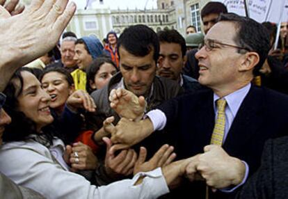 Uribe estrecha la mano de sus seguidores tras votar ayer en Bogotá.