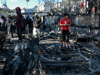 Varias personas junto a los restos del incendio dentro del campo de refugiados de Moria este lunes, en la isla griega de Lesbos.