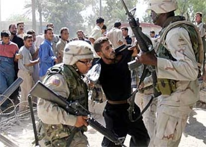 Dos soldados estodounidenses detienen a un antiguo miembro del Ejército iraquí en Bagdad.