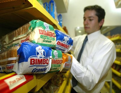 Un trabajador repone productos en un establecimiento de Bimbo.