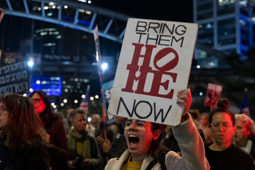 TEL AVIV, ISRAEL - JANUARY 14: A protester holds a sign during a demonstration calling for the return of hostages held by Hamas after the deadly Oct 7 attack January 14, 2025 Tel Aviv, Israel. This week saw a fresh round of media reports about a phased ceasefire and hostage deal between Israel and Hamas being in its "final stages." (Photo by Amir Levy/Getty Images)