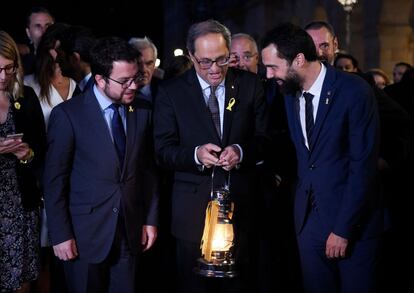 El presidente de la Generalitat Quim Torra y el presidente del Parlament Roger Torrent sostienen un farolillo durante su participación en la 'Flama del Canigó'.