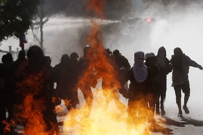 Os encapuzados atacaram os policiais com bombas molotov.