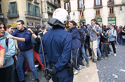 Un policía vigila la fila de manifestantes en una calle de Barcelona.