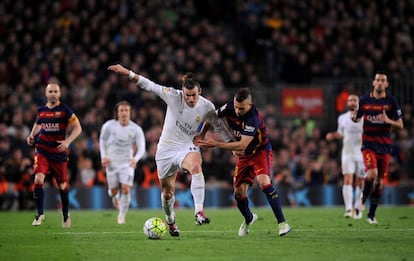Bale intenta conducir el balón acosado por Alba.
