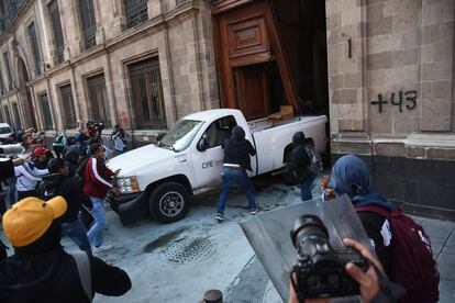 Estudiantes de la Escuela Normal Rural "Raúl Isidro Burgos" derriban la.puerta de Palacio Nacional, el 6 de marzo 2024.