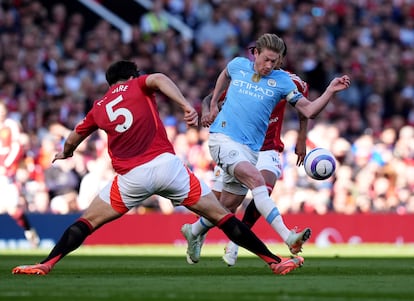 Kevin De Bruyne (derecha) regatea a Harry Maguire durante el derbi de Mánchester entre United y City.