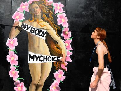 Una mujer observa una pintada a favor del aborto.