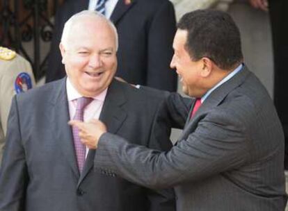 Hugo Chávez (derecha) conversa con Moratinos (izquierda) durante el acto de firma de acuerdos bilaterales sobre energía entre España y Venezuela.