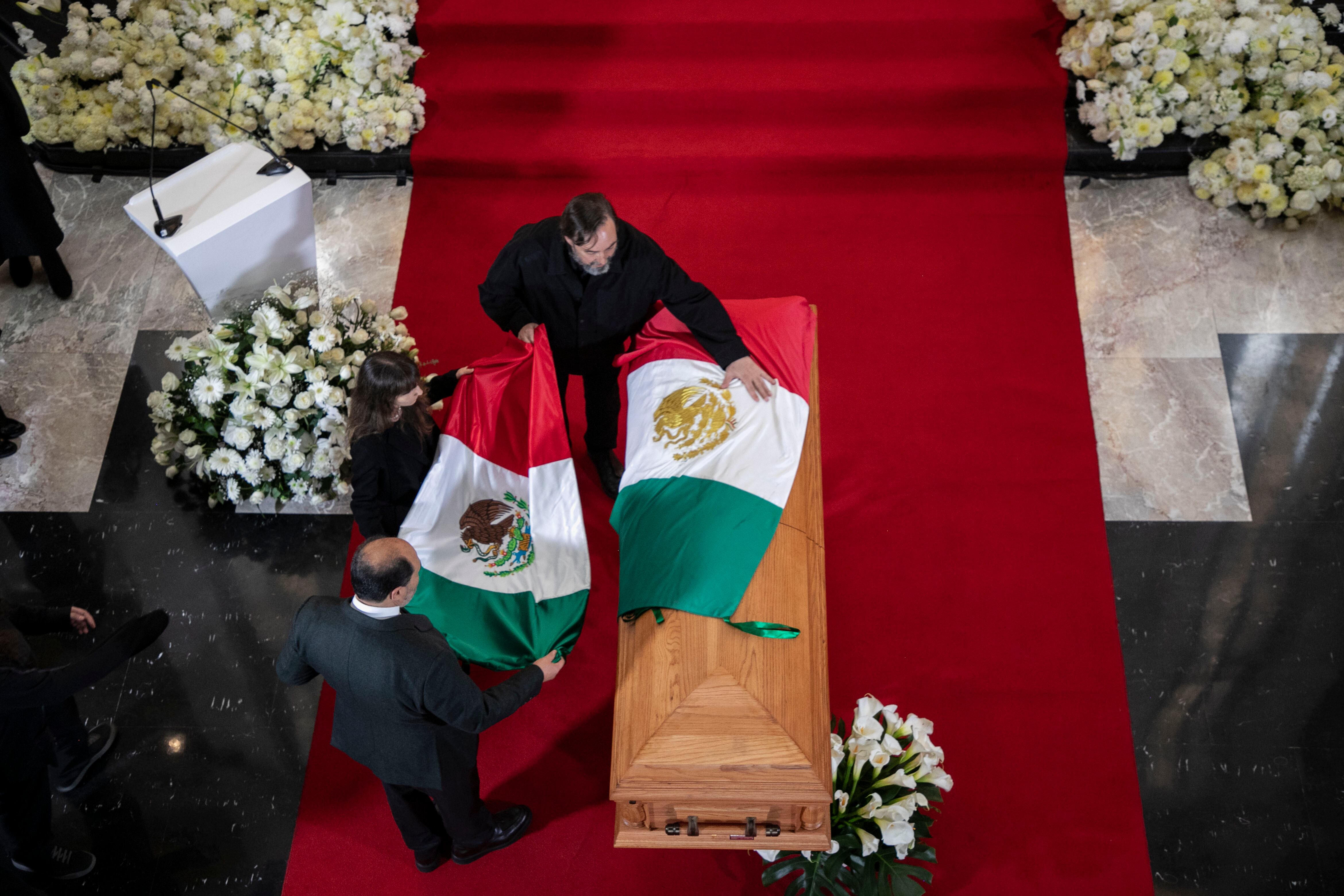 Familiares colocan banderas en la tumba de Cuauhtémoc Cárdenas.
