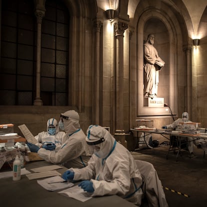 BARCELONA, SPAIN - FEBRUARY 14: Election workers wear protective equipment during the final hour of voting, which was allocated to also allow those who are COVID-positive or who are in quarantine to cast their ballots, at Barcelona University during regional Catalan elections on February 14, 2021 in Barcelona, Spain. In a survey, a third of those chosen by a draw to perform the civic duty of running polling locations on election day said they are worried about the risk of Covid-19 contagion. Spain has been amongst the worst-hit nations by the Coronavirus pandemic, and although the average number of infections has fallen the death rate remains high. (Photo by Finbarr O'Reilly/Getty Images)