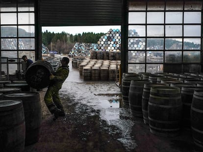 Un trabajador levanta una barrica de whisky en la destilería Speyside Cooperage, en Craigellachie, Escocia.