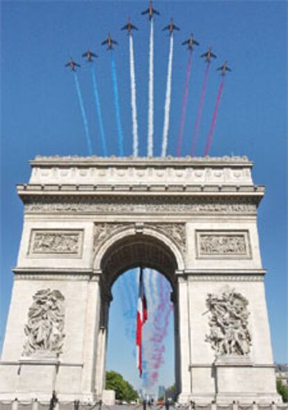 Una escuadrilla de aviones traza la bandera francesa sobre el Arco de Triunfo.