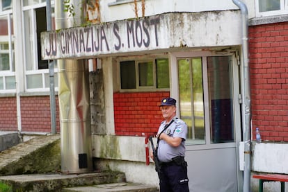 Un policía vigila la entrada del instituto en el que ha ocurrido el tiroteo, este miércoles en Sanski Most (Bosnia-Herzegovina).