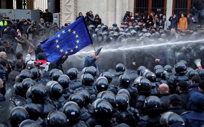 La policía antidisturbios dispersa a los manifestantes durante una protesta frente al edificio del parlamento en Tbilisi (Georgia).