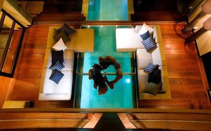 Salón con vistas a la piscina a tavés del suelo de cristal, en Villa Shore, Bali (Indonesia)