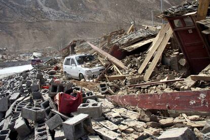 Un coche enterrado por los escombros en el condado de Yushu, epicentro del terremoto que sacudió ayer la provincia de Qinghai.