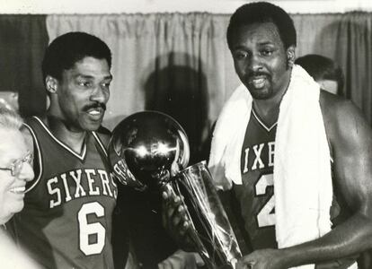 Dr. J y Moses Malone (8º anotador histórico con 27.409 puntos) posan con el trofeo de campeón de la NBA en 1983. Aquel año, Malone promedió 25,8 puntos por partido y logró el MVP de las finales tras ganar 4-0 a los Lakers.