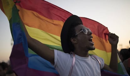 Homem levanta a bandeira LGBTQ durante o Rock in Rio, no último domingo.